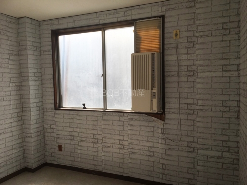 白いレンガ調の壁とエアコンの内装の画像