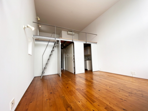 白とウッドの床材、ロフトスペースが映った開放的な室内の画像