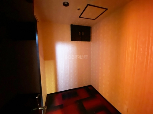 ラウンジにある個室内の白い内装と赤黒の絨毯の画像